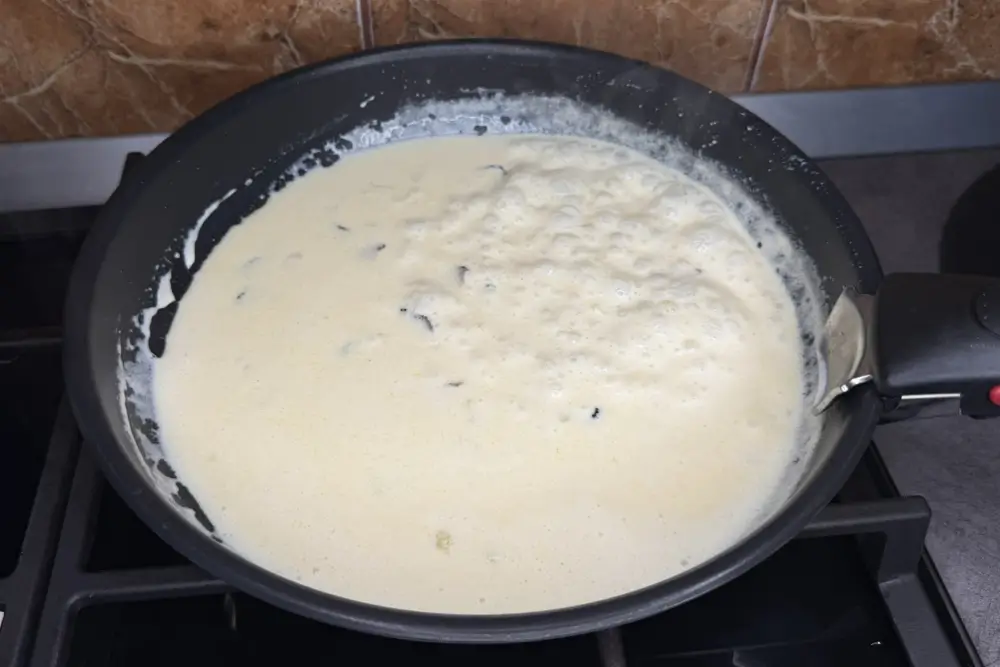 Adauga parmezan in sosul alb cu trufe pentru paste